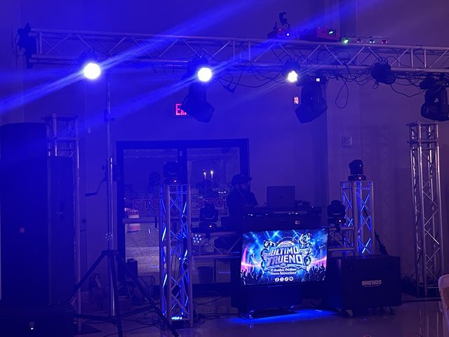 Truss, beam lights and the Sonido Ultimo Trueno logo screen set up at the booth